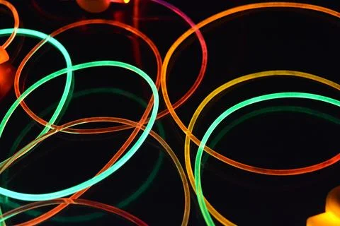 Color motion blurred magic neon red, blue, green, yellow light circles, lines. Stock Photos
