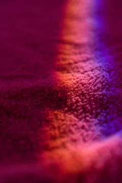 Color ray of light running through prism on wine red carpet Stock Photos