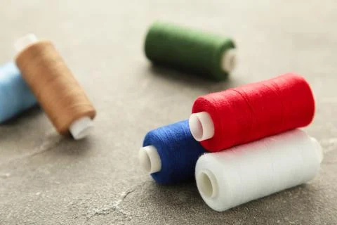 Color sewing threads on grey background Stock Photos