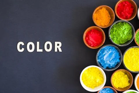 Color text with different types holi color powder bowl black background Stock Photos