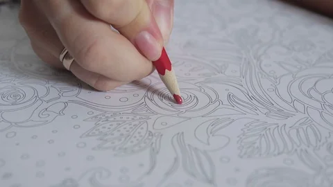 Color video of a woman hand holding a pencil drawing and coloring coloring book Stock Footage