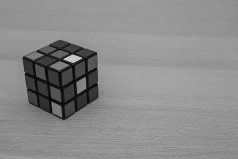 Colored 3D combination puzzle Rubik's cube three by three lies on a wooden ta Stock Photos