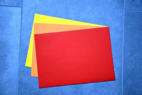 Colored a4 sheets on blue-gray background red color 스톡 사진