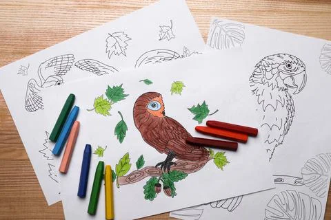 Colored and blank drawings with crayons on wooden table, flat lay Foto stock