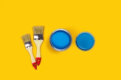 Colored background with paint jar and brushes. Stock Photos