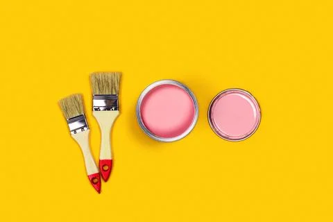 Colored background with paint jar and brushes. Stock Photos