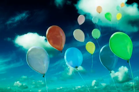 Colored ballons against cloudy sky Stock Photos