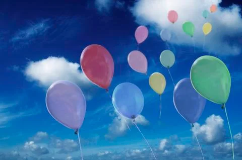 Colored ballons against cloudy sky Stock Photos