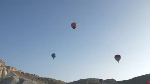 Colored balloons in the sky against the background of white rocks at sunrise. Cr Stock Footage 151139352