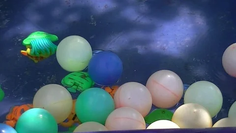 Colored balls and toys float in the water Stock Footage 92978504