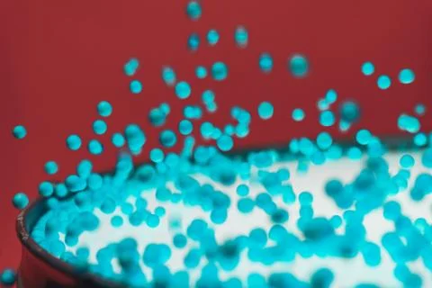 Colored balls bounces off drum in shockwave pattern. Beautiful red background 스톡 사진