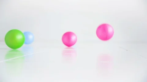 Colored Balls Bouncing on the Floor in a White Room Holiday and Fun Concept Video stock 128338104