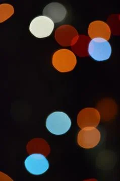 Colored bokeh on a black background. flashing lights of the garland. decoration Stock Photos
