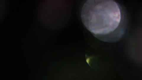 Colored bokeh in motion blurs the blackness. Vídeo Stock 318729722