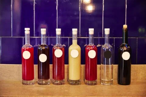 Colored Bottles with different drinks on background Stock Photos