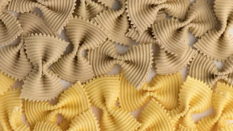Colored bow tie pasta. Closeup multiple farfalle isolated on white background. Stock Footage 136332638
