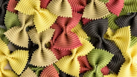 Colored bow tie pasta. Closeup multiple farfalle on white background. Stock Footage 136491329