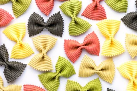 Colored bow tie pasta. Closeup multiple farfalle on white background. Stock Photos