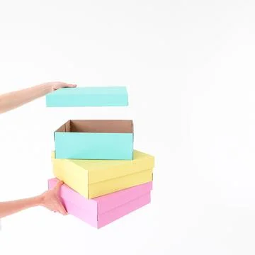 Colored boxes are held and opening on a white background. There is space fo.. Stock Photos