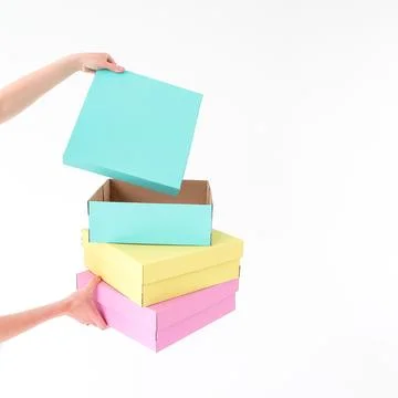 Colored boxes are held and opening on a white background. There is space fo.. Stock Photos