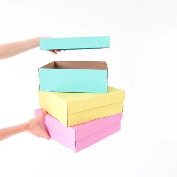 Colored boxes are held and opening on a white background. There is space fo.. Stock Photos