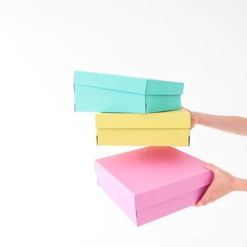 Colored boxes are held and opening on a white background. There is space fo.. Stock Photos