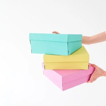 Colored boxes are held and opening on a white background. There is space fo.. Stock Photos