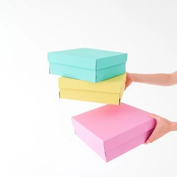 Colored boxes are held and opening on a white background. There is space fo.. Stock Photos