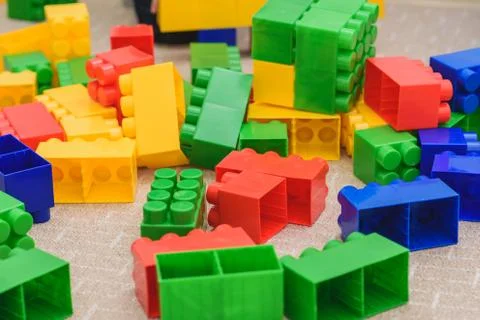 The colored bricks of the designer are lying on the floor Stock Photos