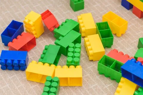 The colored bricks of the designer are lying on the floor Stock Photos