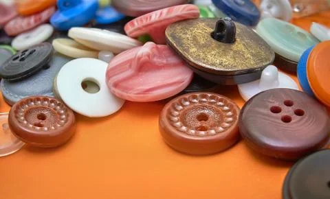 Colored button stitching on orange background Stock Photos