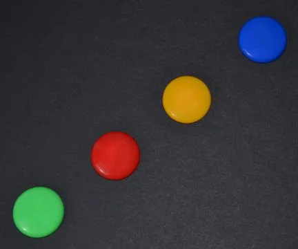 Colored buttons on a black table. Stock Photos