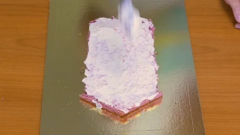 Colored cake sponge cake in the form of a house Smear with cream Stock Footage 123576999
