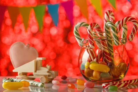 Colored candy on blurred bokeh background. Pink heart on a toy truck. A sweet 스톡 사진