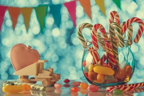 Colored candy on blurred bokeh background. Pink heart on a toy truck. A sweet Stock Photos