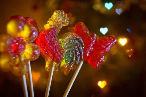 Colored candy on a stick in the form of a cockerel heart and flowers Stock Photos