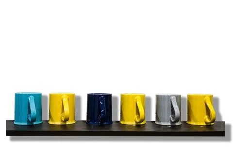 Colored ceramic coffee mug placed on a glass shelf made of wood. Isolated on  Stock Photos