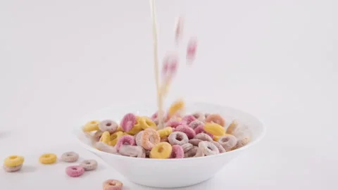 Colored cereals, dry breakfasts for children are poured into a bowl. Stock-Footage 196120345