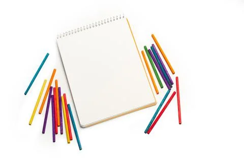 Colored chalks and a blank note pad on a white background with copy space 스톡 사진