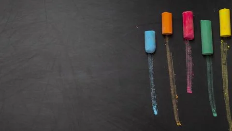 Colored chalks on black chalkboard background Stock Photos