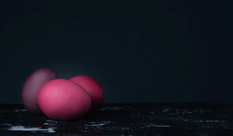 Colored chicken eggs on a dark background. Easter eggs. Place for an inscription Stock Photos
