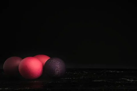 Colored chicken eggs on a dark background. Easter eggs. Place for an inscription Stock Photos