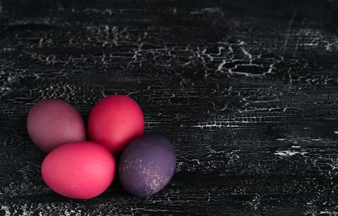 Colored chicken eggs on a dark background. Easter eggs. Place for an inscription Stock Photos
