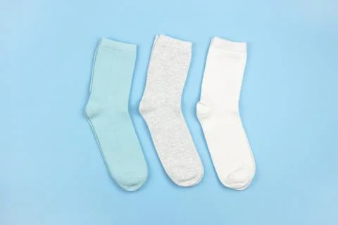 Colored children's socks without pattern, blue, gray, white on blue backgroun Stock Photos
