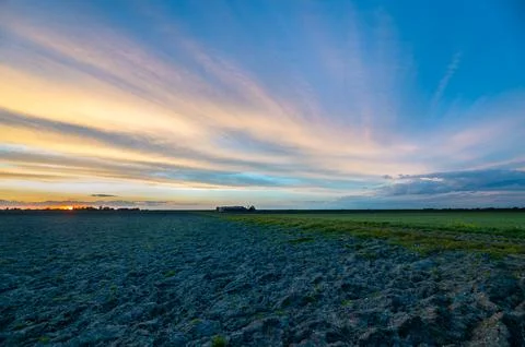 Colored cirrus clouds over empty desolate farmland Stock Photos
