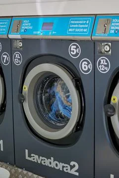 Colored clothes are drying in a dryer in a laundromat Stock Photos