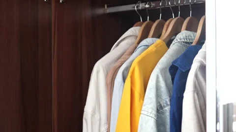 Colored clothes on hangers in the closet. Decluttering the cabinet Stock Footage 263908835
