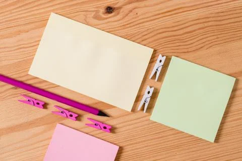 Colored clothespin placed around the empty rectangle square shaped reminder note Stock Photos