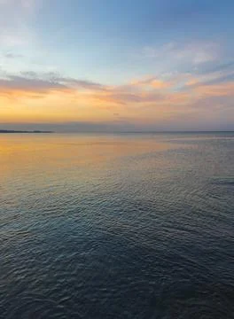 Colored clouds over the sea at sunset Stock Photos
