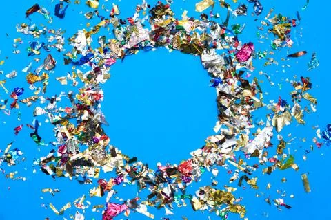 Colored confetti flying on blue background Stock Photos